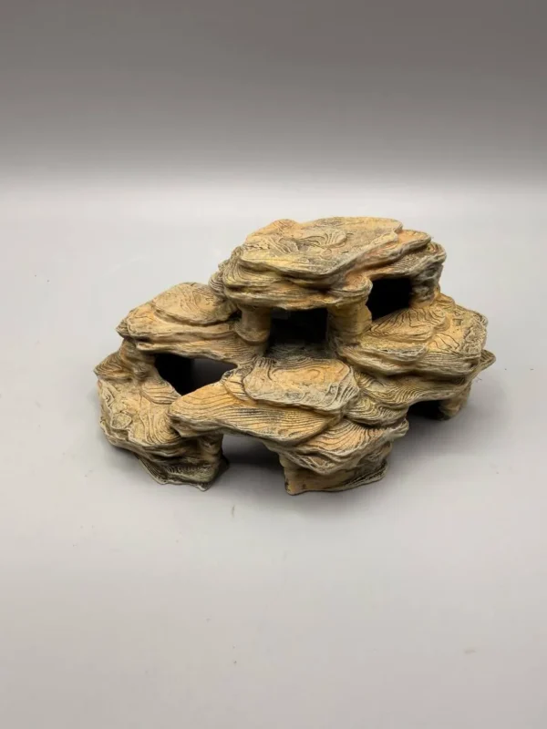 cachette-rocheuse-multi-niveaux-terrarium Zoom sur les détails fins d'une cachette rocheuse pour terrarium montrant les strates sédimentaires et la précision des couches d'impression 3D.