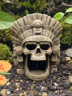 cachette-crane-azteque-pla Vue de face d'un crâne décoratif en PLA à personnaliser posé sur un fond clair, dévoilant sa grande mâchoire ouverte et sa coiffe de plumes détaillée.