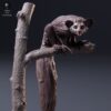 Figurine de lémurien aye-aye aux grands yeux et doigts effilés perchée sur une branche d'arbre sculptée à l'échelle 1/8.